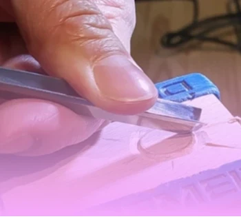 main qui sculpte le bois