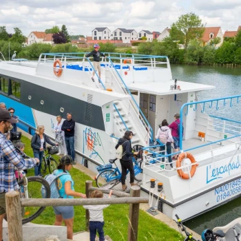 groupe de cycliste qui descend vers une péniche