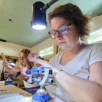 femme concentrée en train de sculpter le bois