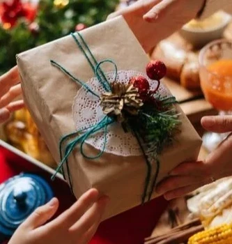 mains qui offrent un cadeaux noël